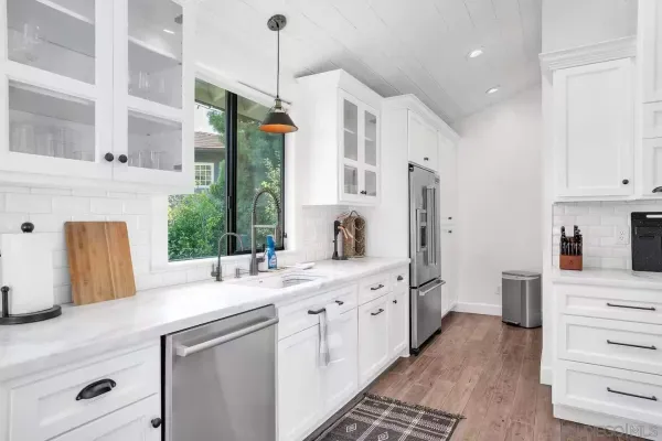 a kitchen with stainless steel appliances kitchen island granite countertop a sink and a refrigerator