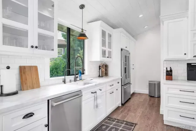 a kitchen with stainless steel appliances kitchen island granite countertop a sink and a refrigerator
