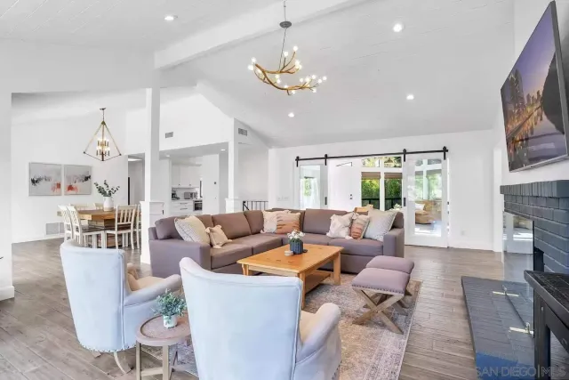 a living room with furniture a fireplace and a chandelier