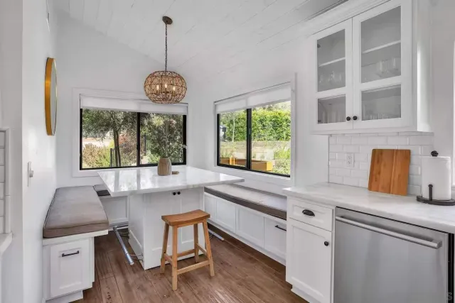 a very nice looking kitchen with granite countertop a stove two sinks and a large window