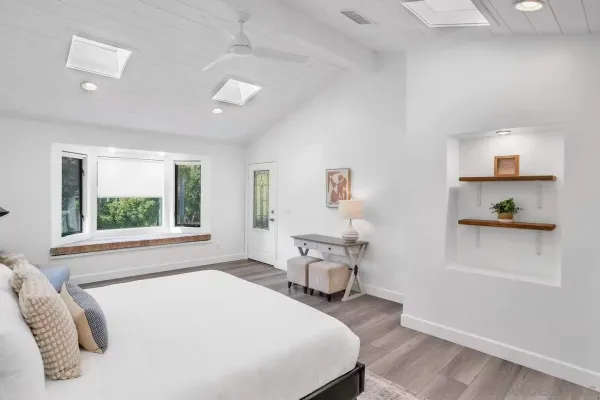 a bedroom with a bed and a large window