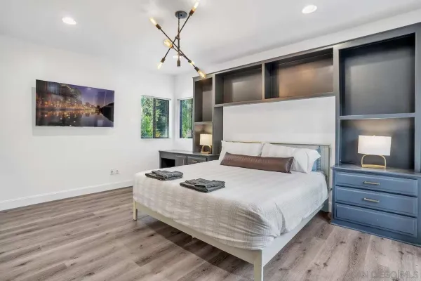 a bedroom with a large bed and a chandelier