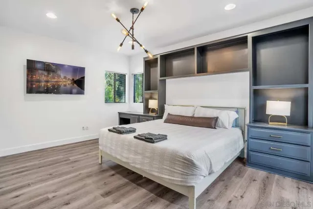 a bedroom with a large bed and a chandelier