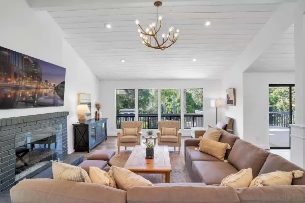 a living room with furniture fireplace and large windows