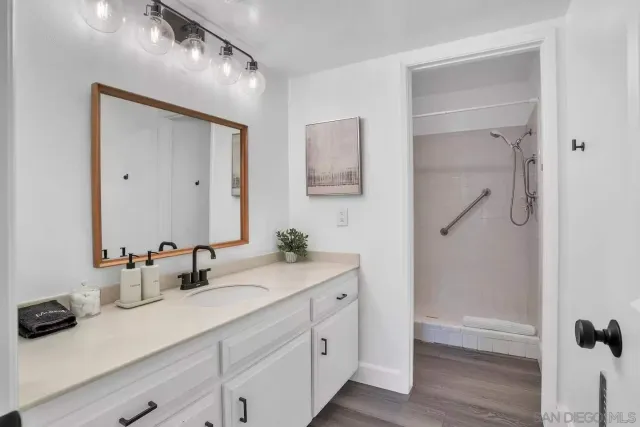 a view of a patio with couches table and chairs under an umbrella with palm trees