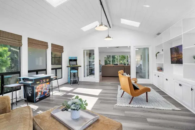 a living room with furniture a flat screen tv and a floor to ceiling window
