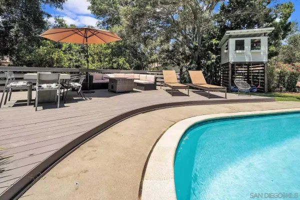 a view of a house with backyard and sitting area