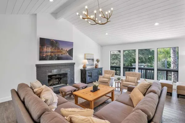 a living room with furniture chandelier and a fireplace