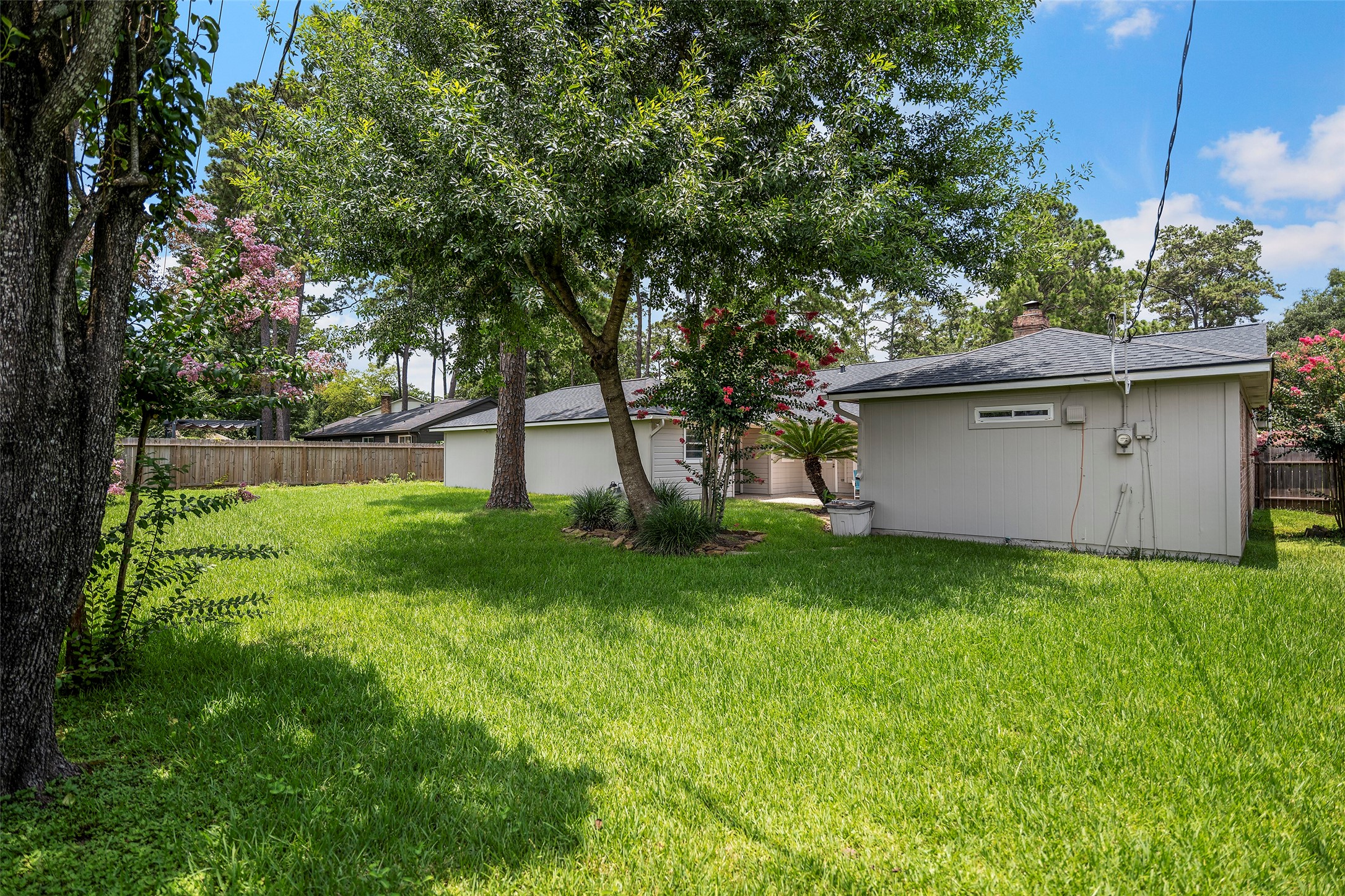 6507 Allentown Drive Spring, TX 77389 - Photo 23 of 30 Backyard view featuring mature trees and a lush, vibrant lawn.