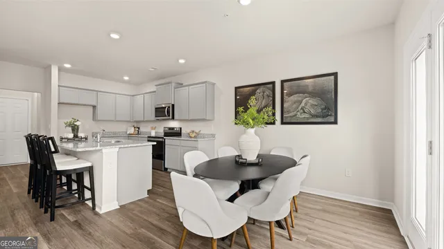 a kitchen with a dining table chairs and refrigerator
