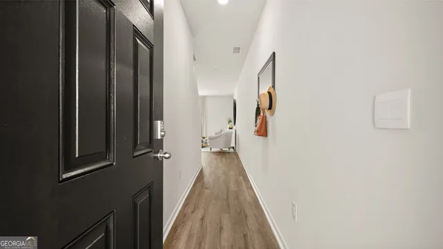 a view of a hallway with wooden floor and staircase