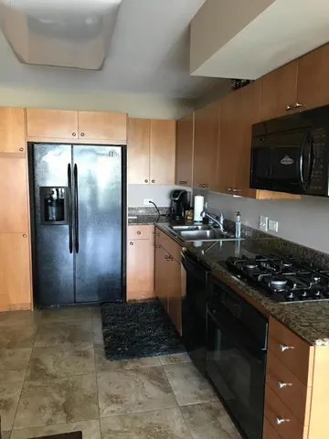 a kitchen with a refrigerator and a stove top oven