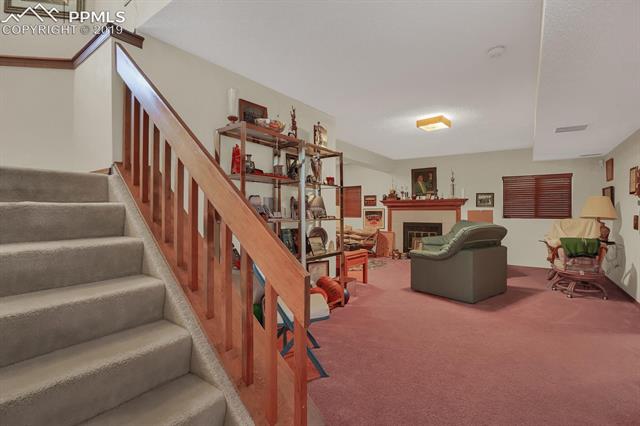 190 Desert Inn Way Colorado Springs, CO 80921 - Photo 22 of 31 Family room. Note that wide stairs have a landing half way down.