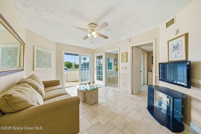 a living room with furniture ceiling fan and a window