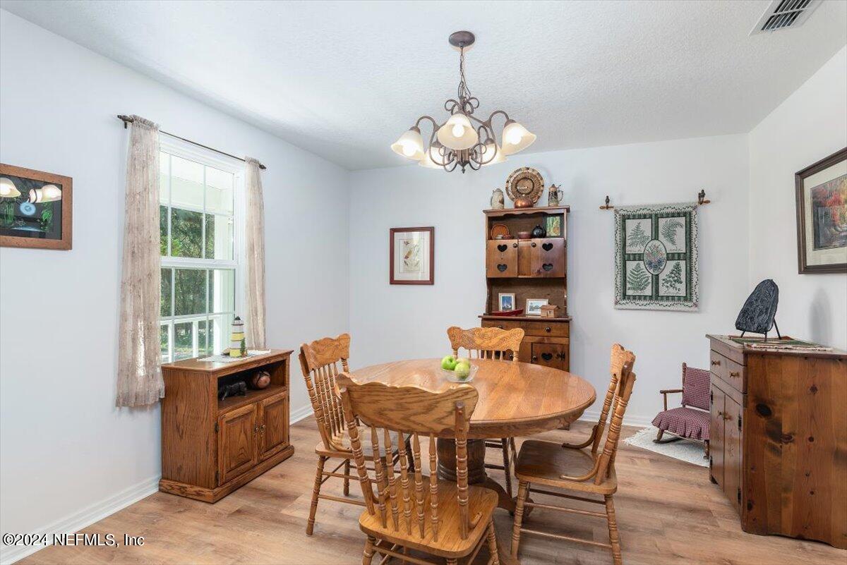 6481 Brooklyn Bay Road Keystone Heights, FL 32656 - Photo 14 of 45 a dining room with furniture a window and a chandelier