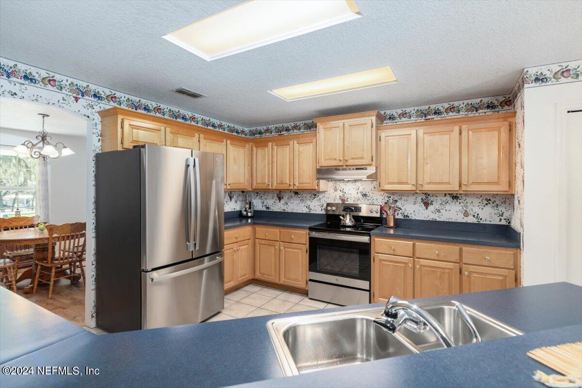 6481 Brooklyn Bay Road Keystone Heights, FL 32656 - Photo 17 of 45 a kitchen with granite countertop a refrigerator stove and sink