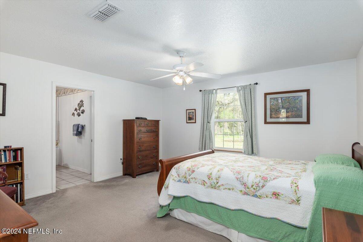 6481 Brooklyn Bay Road Keystone Heights, FL 32656 - Photo 20 of 45 a bedroom with a large bed and a chandelier