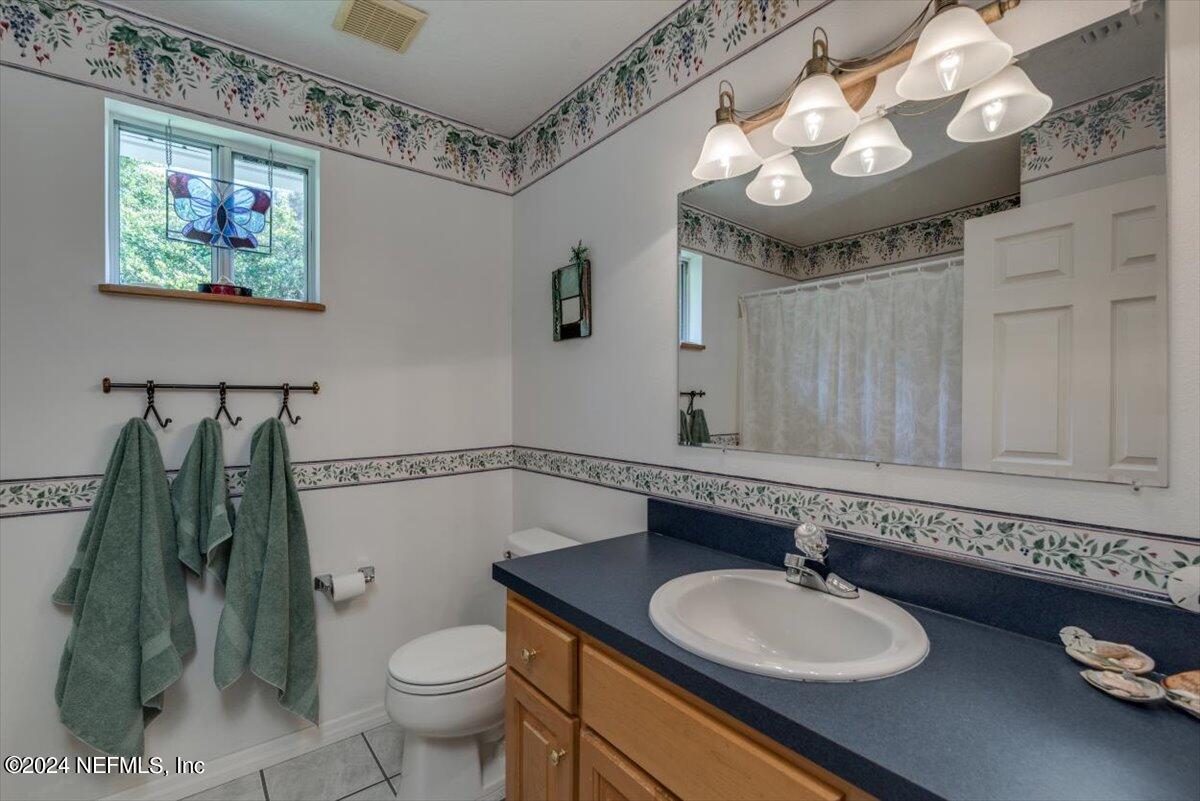 6481 Brooklyn Bay Road Keystone Heights, FL 32656 - Photo 25 of 45 a bathroom with a granite countertop sink a toilet and a mirror