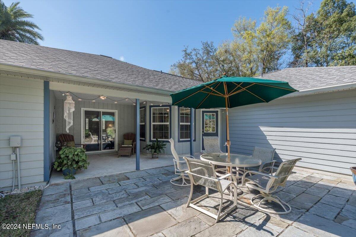 6481 Brooklyn Bay Road Keystone Heights, FL 32656 - Photo 31 of 45 a patio with a table and chairs under an umbrella