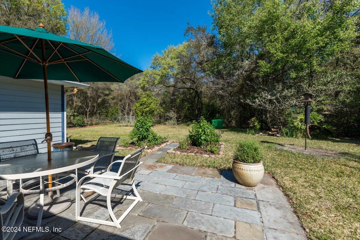 6481 Brooklyn Bay Road Keystone Heights, FL 32656 - Photo 34 of 45 a view of a patio with table and chairs under an umbrella