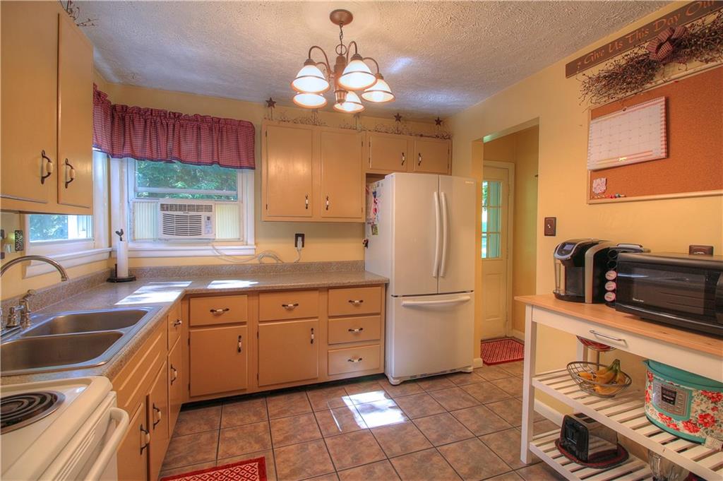 687 Park Road Beaver Falls, PA 15010 - Photo 6 of 22 The farm style KITCHEN has painted cabinets and ceramic floor. Electric range is included. Door on right leads to small side porch.