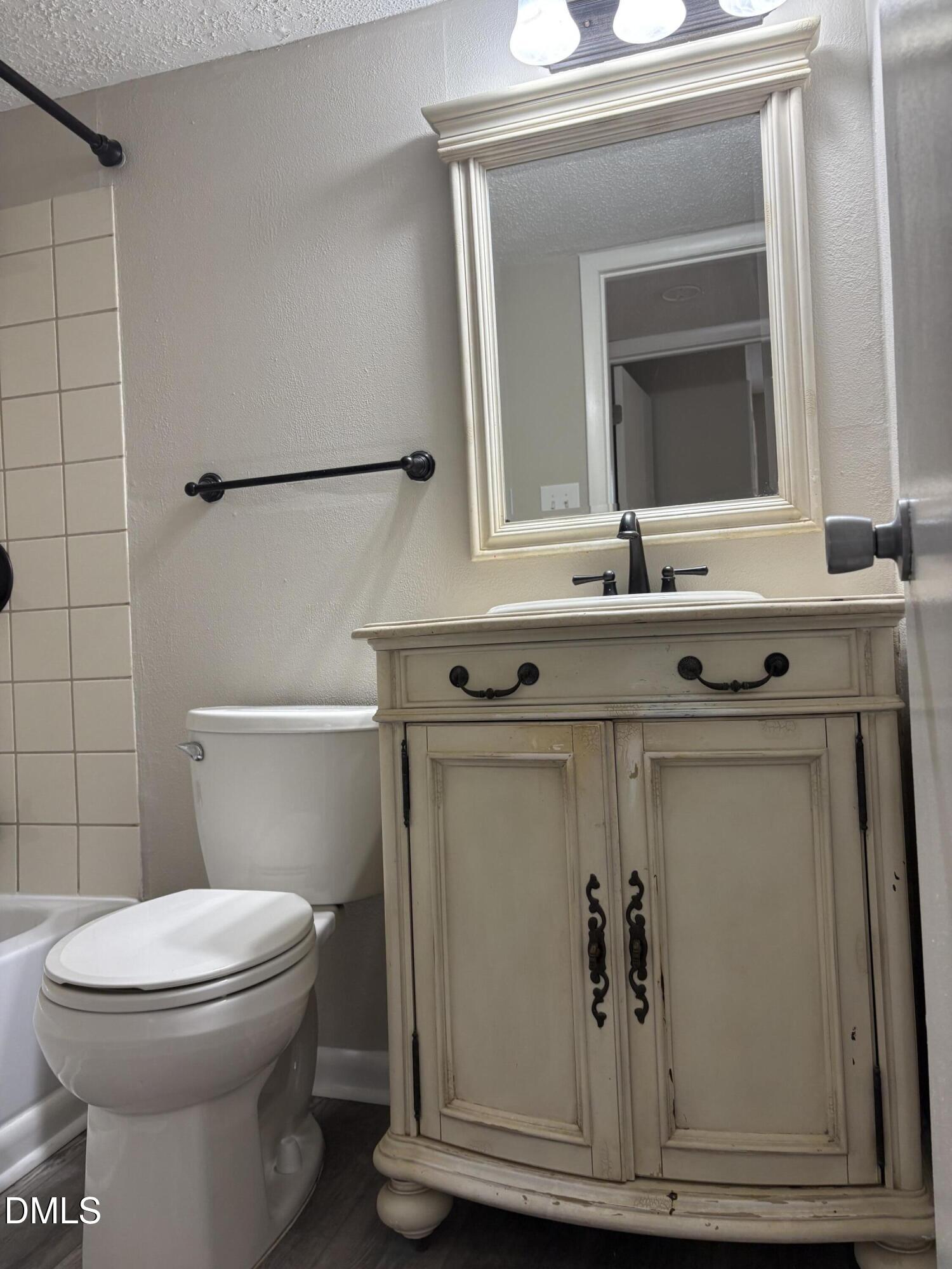 533 Pine Ridge Place Raleigh, NC 27609 - Photo 2 of 9 a bathroom with a toilet sink and mirror