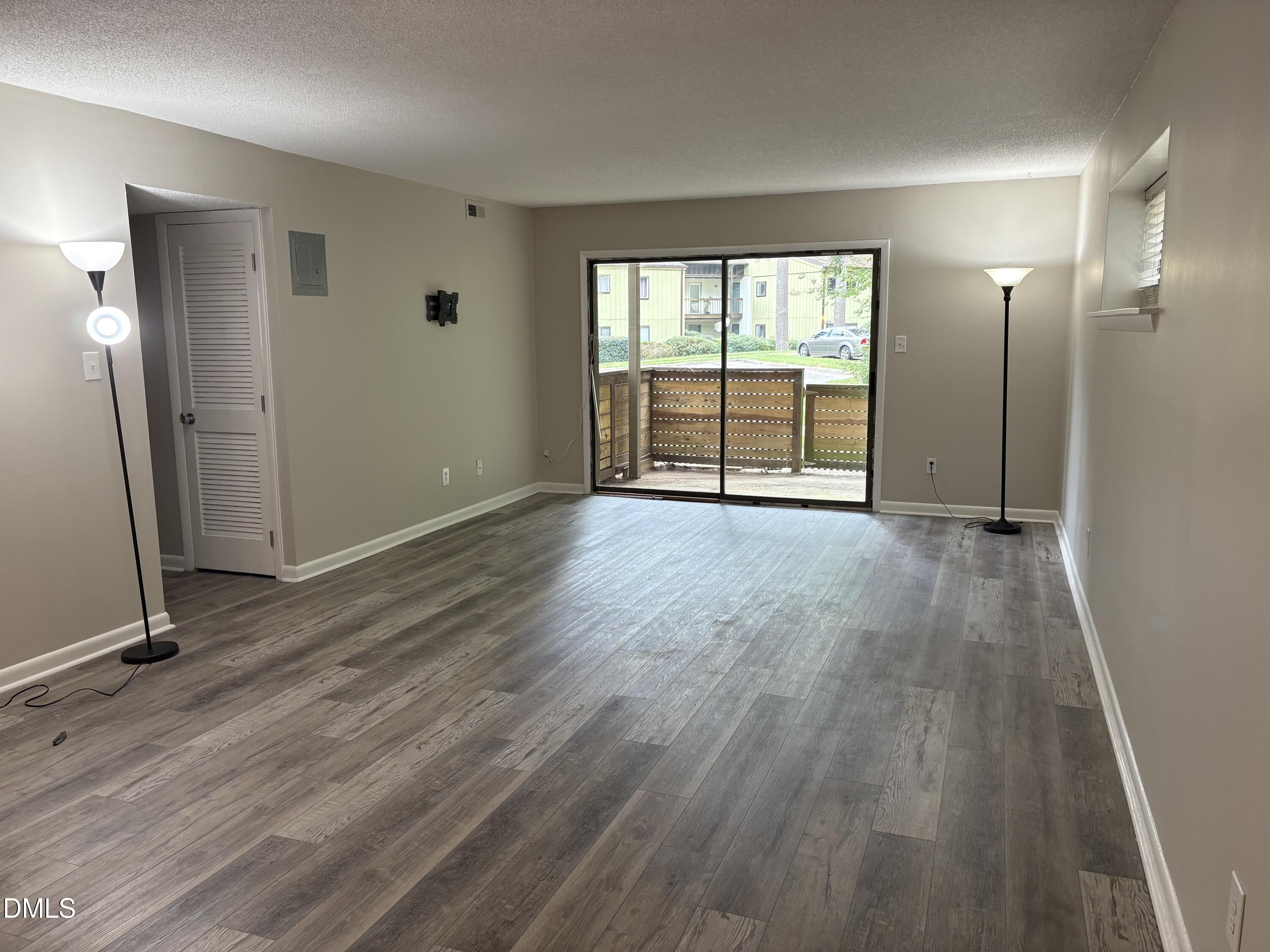 533 Pine Ridge Place Raleigh, NC 27609 - Photo 5 of 9 an empty room with wooden floor and windows