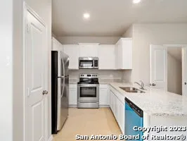 a kitchen with stainless steel appliances granite countertop a refrigerator stove and sink