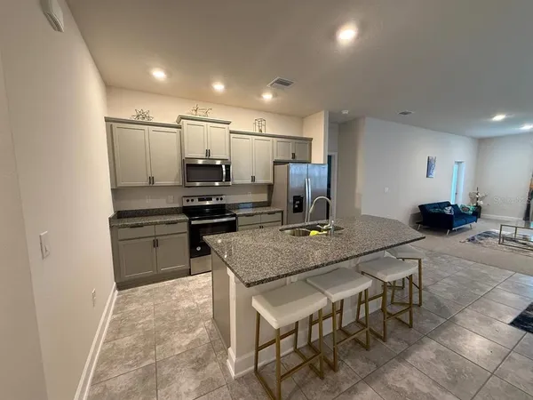 a kitchen with kitchen island a stove a table and chairs
