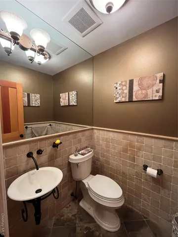 a bathroom with a toilet a sink and mirror