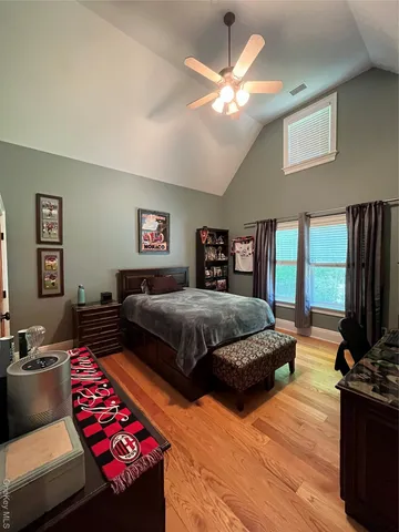 a bedroom with a bed and wooden floor