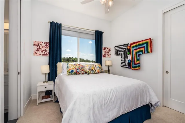 a bed sitting in a spacious bedroom next to a window