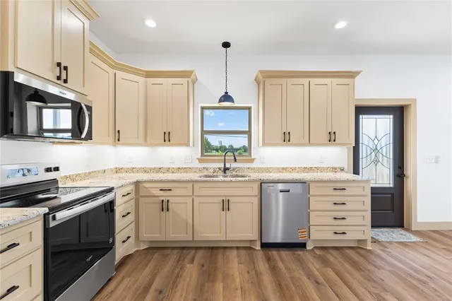 a view of a kitchen with white cabinets and wooden floor