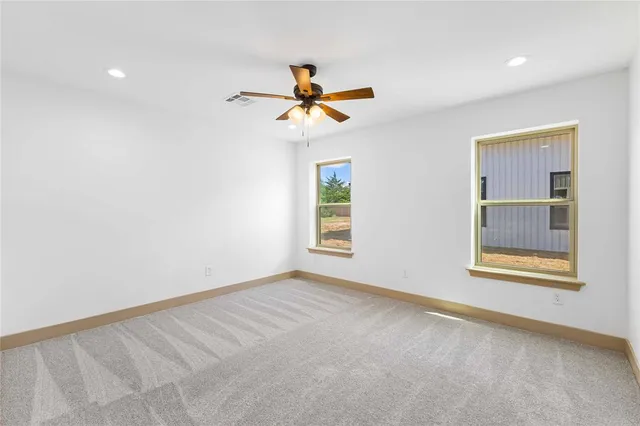 an empty room with fan and windows