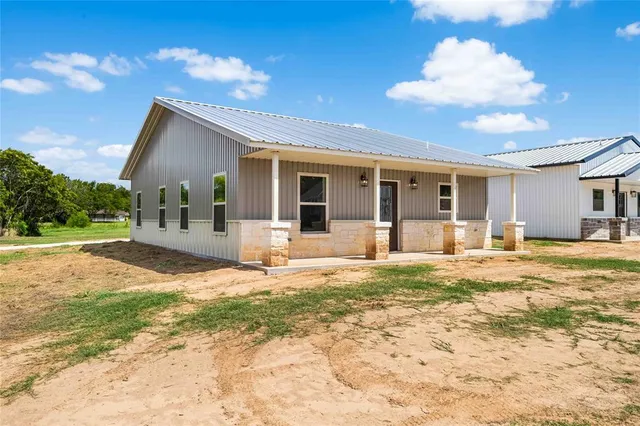 a view of a house with backyard and porch