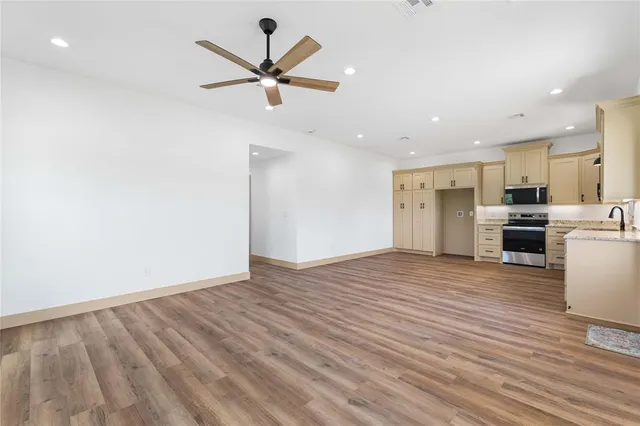 a view of a kitchen with a fridge wooden floor and a window