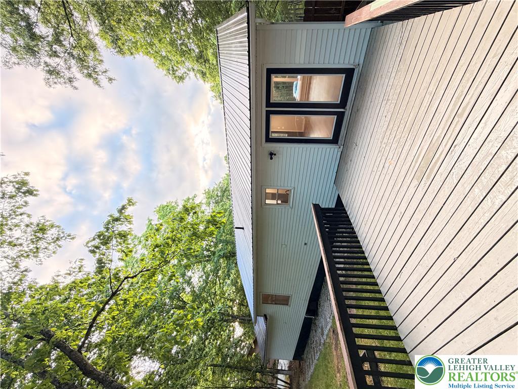 182 Mountain Road Albrightsville, PA 18210 - Photo 4 of 17 A spacious wooden deck provides ample outdoor living space, complementing the clean lines of the home's exterior.