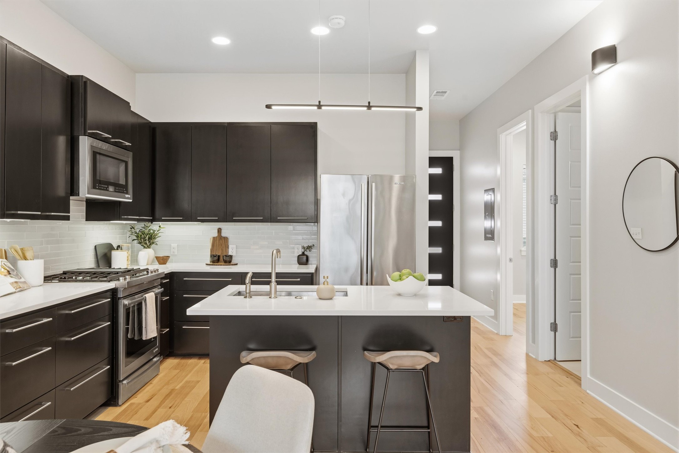 2314 Enfield Road, Unit 203 Austin, TX 78703 - Photo 3 of 37 Espresso cabinetry, quartz countertops, and stainless steel appliances make this kitchen as functional as it is striking.