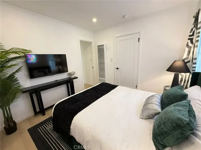 a bedroom with a bed and a flat screen tv