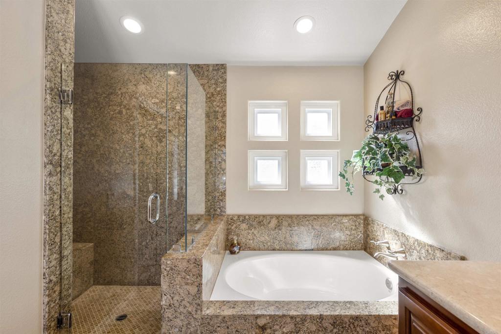 4926 Tilos Way Oceanside, CA 92056 - Photo 41 of 63 a bathroom with a granite countertop sink a bathtub and shower