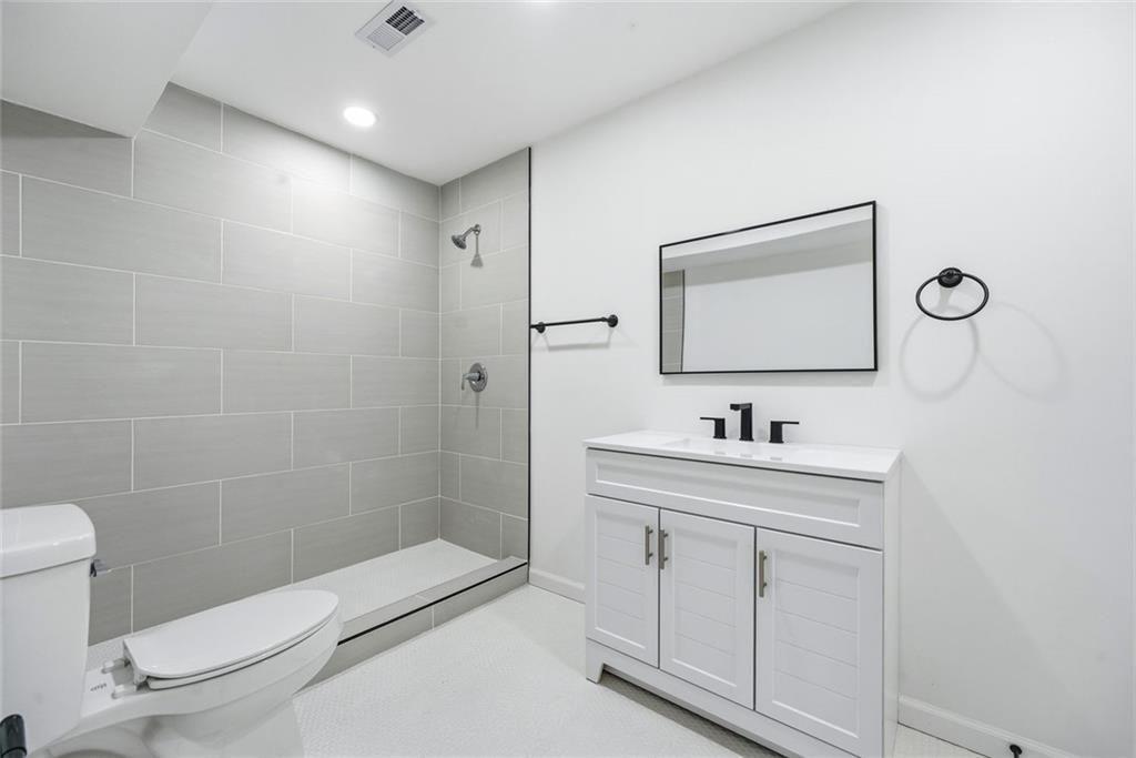 2277 Edgemore Drive Southeast Atlanta, GA 30316 - Photo 42 of 48 a bathroom with a toilet a sink a mirror and shower