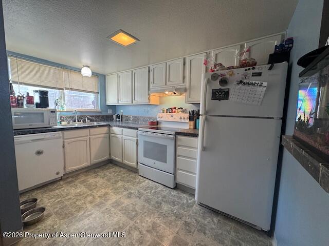 1018 East 7th Street Craig, CO 81625 - Photo 2 of 10 a kitchen with white cabinets and white appliances