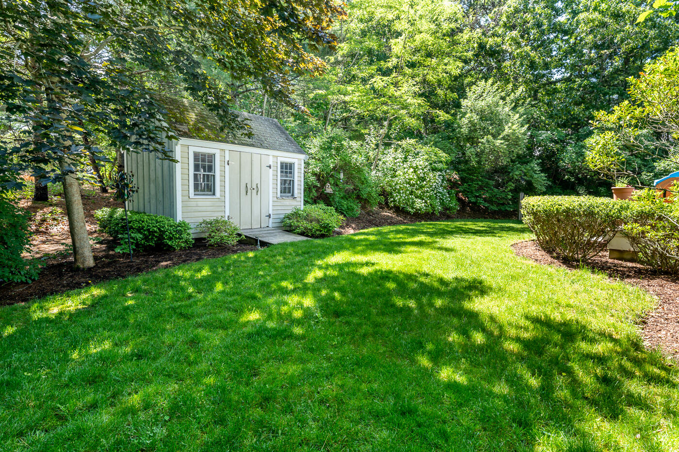 5 Oldham Road Osterville, MA 02655 - Photo 27 of 29 a backyard of a house with plants and large trees