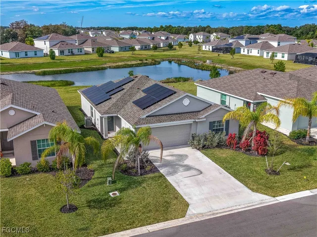 an aerial view of a house with a yard basket ball court and a fire pit