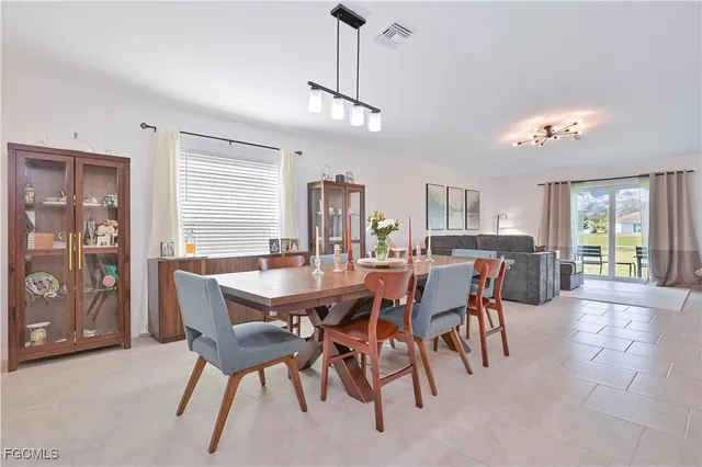 a view of a dining room and livingroom with furniture a rug a kitchen and chandelier