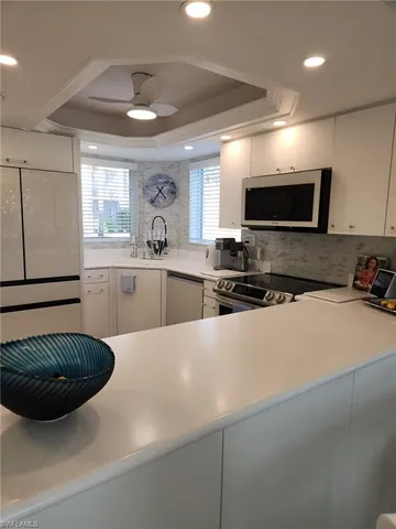 a kitchen with stainless steel appliances a stove a sink a microwave a refrigerator and cabinets