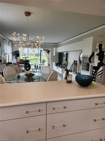 a kitchen with sink a large window and cabinets