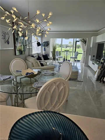 a living room with patio furniture and a chandelier