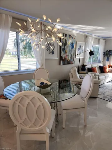 a view of a dining room with furniture and chandelier