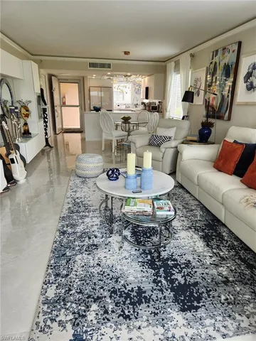 a living room with furniture chess table and a window